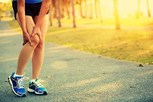 woman holding sore knee from running